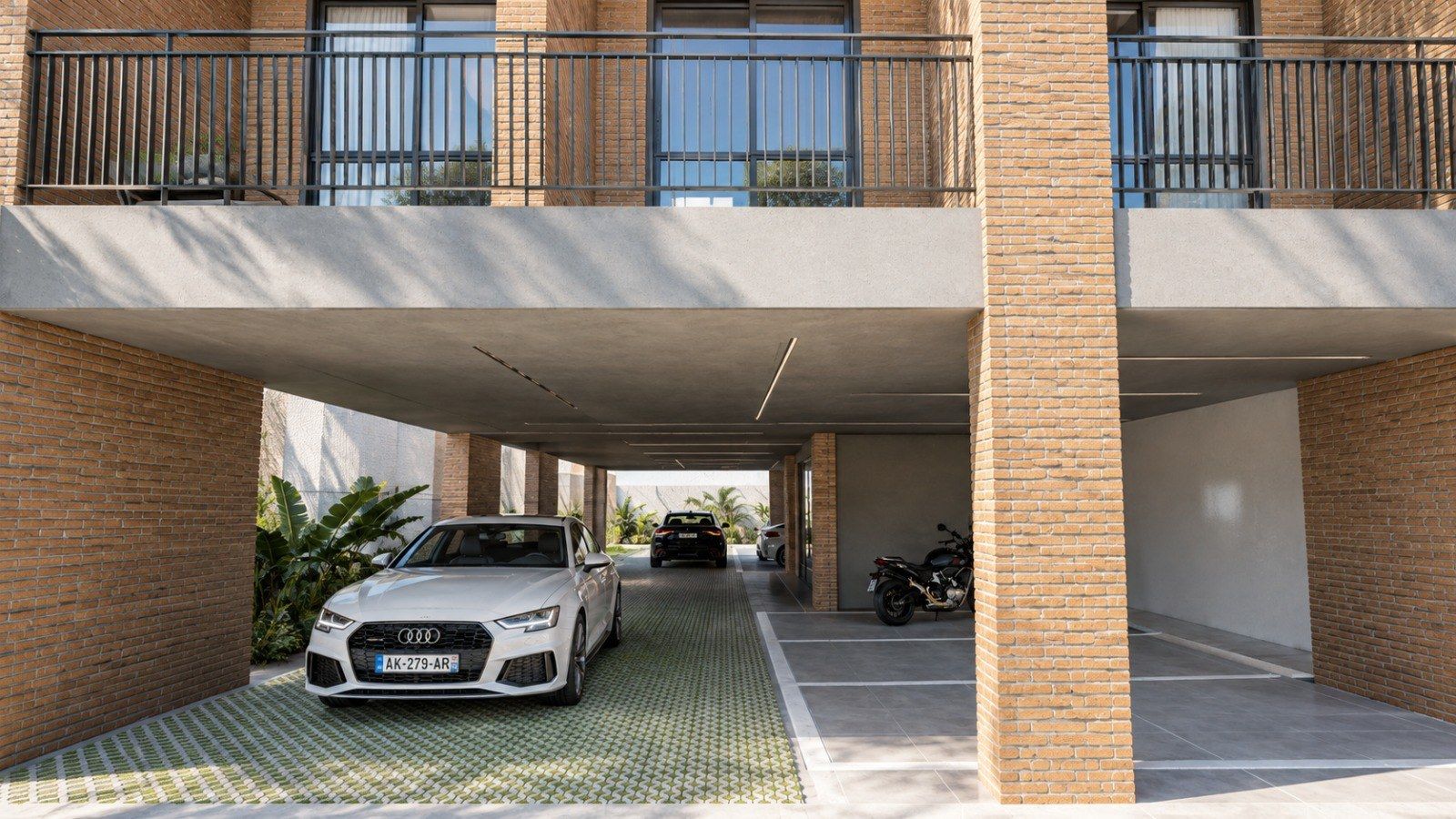 Ground floor from the street — brick piers framing the covered parking and the entrance